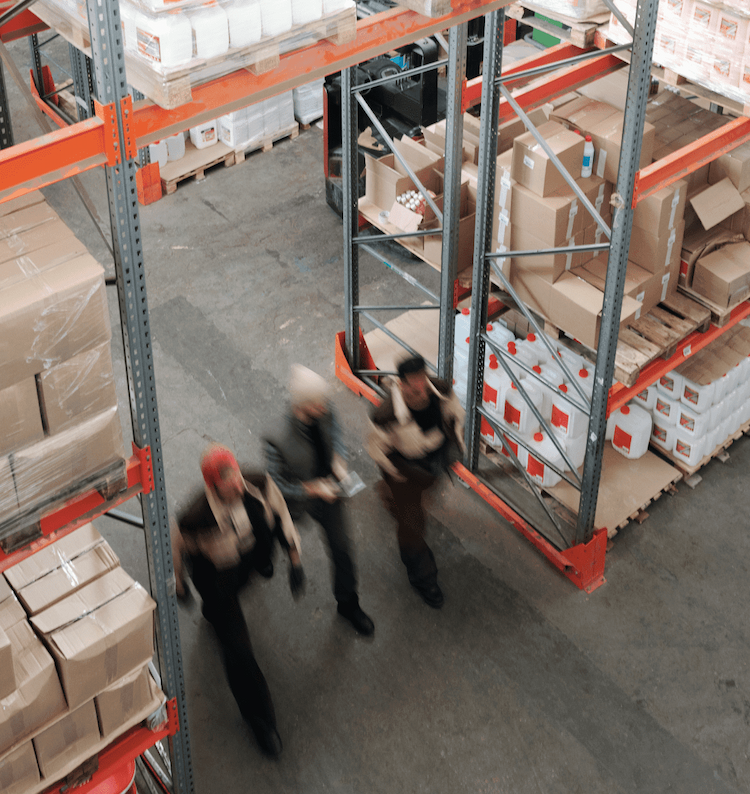 Three workers walk through warehouse